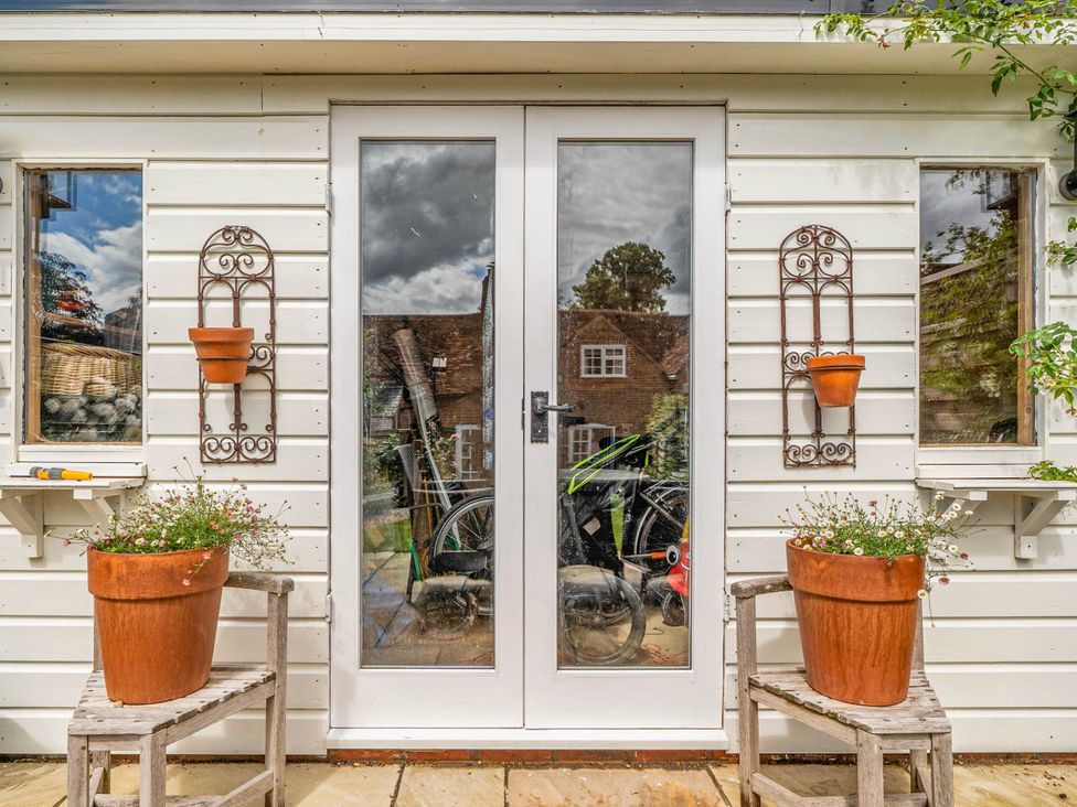 An outdoor area with double doors and plant pots at Cottage Sleeps 4 with Enclosed Garden in Turville near Henley-On-Thames