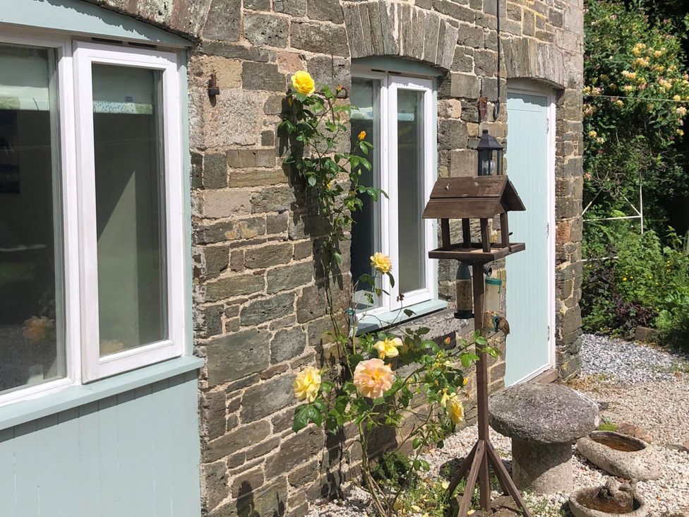 An outdoor view featuring a birdhouse and roses at 1 bed cottage Parking Patio close to coasts Coads Green near Launceston