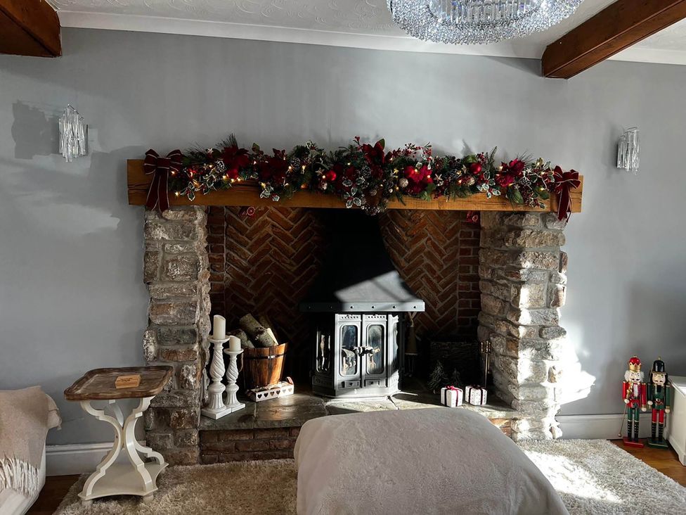 A living room with a fireplace and decorative garland at Build your memories hot tub garden sleeps 14 in Nottage