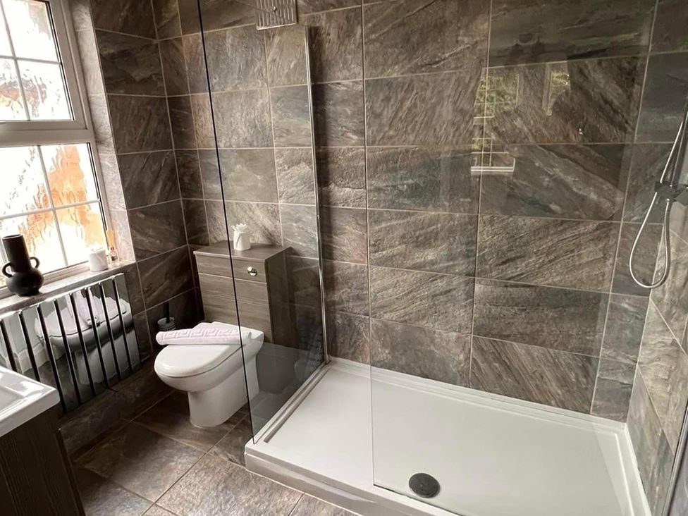 A bathroom with a toilet, sink, and shower at Build your memories hot tub garden sleeps 14 in Nottage