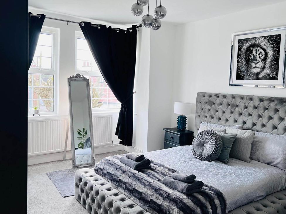 A bedroom with a bed and a mirror at Build your memories hot tub garden sleeps 14 in Nottage