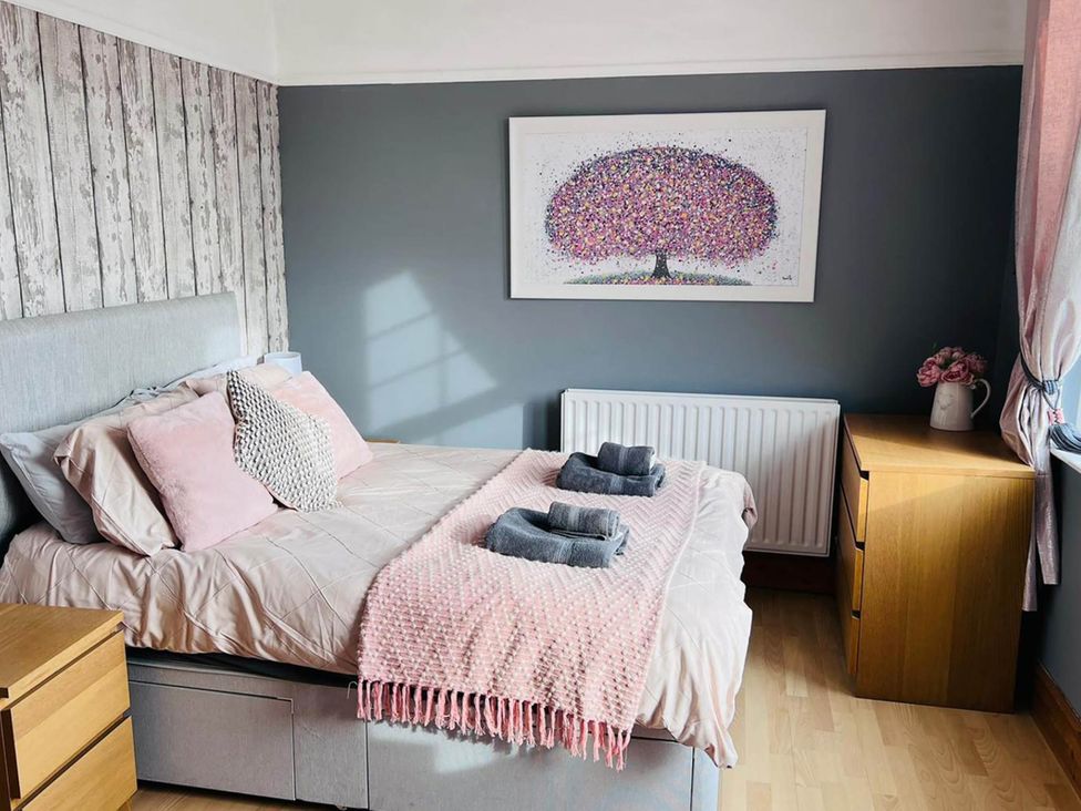 A bedroom with a bed and wall art at Build your memories hot tub garden sleeps 14 Nottage