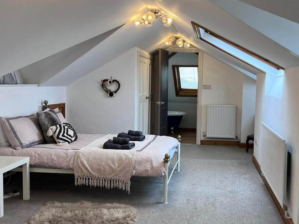 A bedroom with a bed and a door leading to a bathroom at Build your memories hot tub garden sleeps 14 Nottage