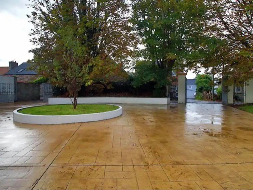 An outdoor area with a central tree and paved flooring at Build your memories hot tub garden sleeps 14 Nottage