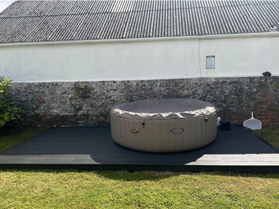 A hot tub on a wooden deck surrounded by grass at Build your memories hot tub garden sleeps 14 Nottage