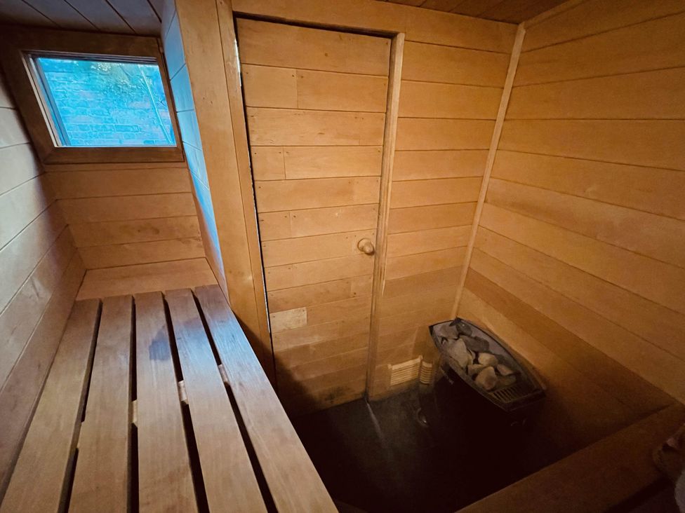 A sauna with wooden benches and a heater at Charming Cottage Sleeps 4 with Sauna in Shaftesbury