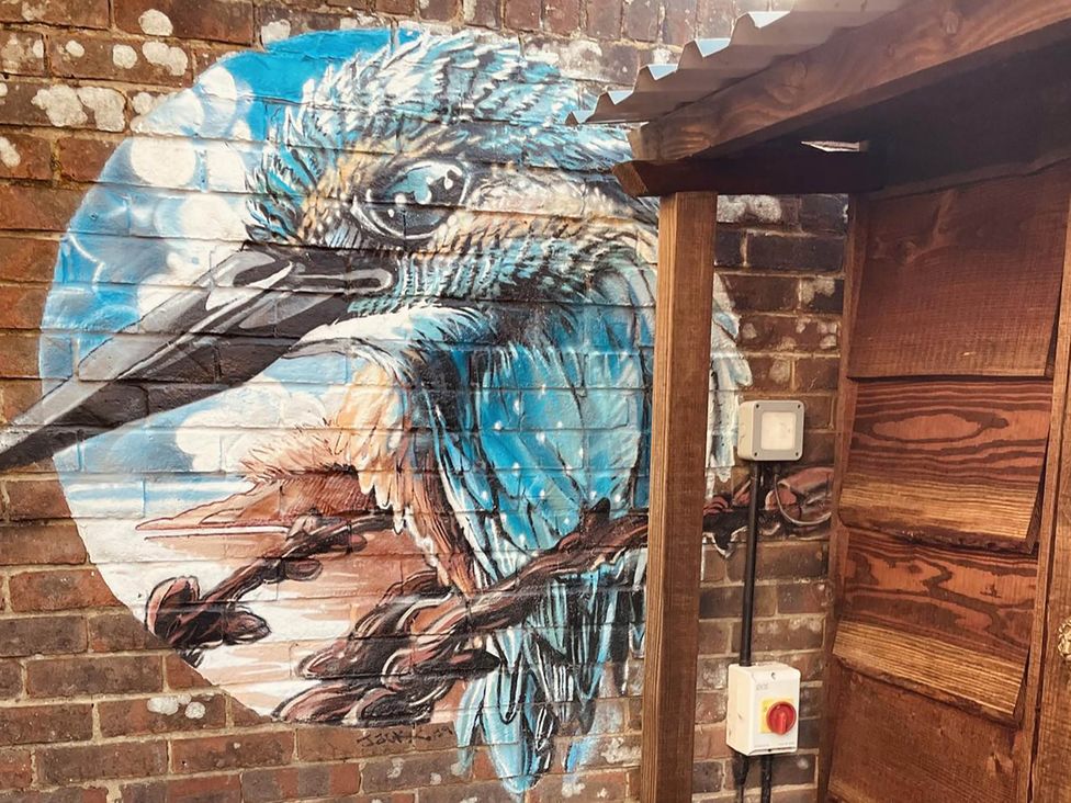 A mural of a bird on a brick wall in an outdoor area