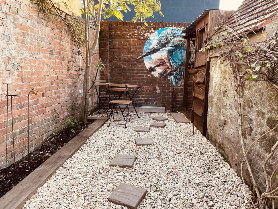 A garden with a brick wall and table and chairs at Charming Cottage Sleeps 4 with Sauna in Shaftesbury