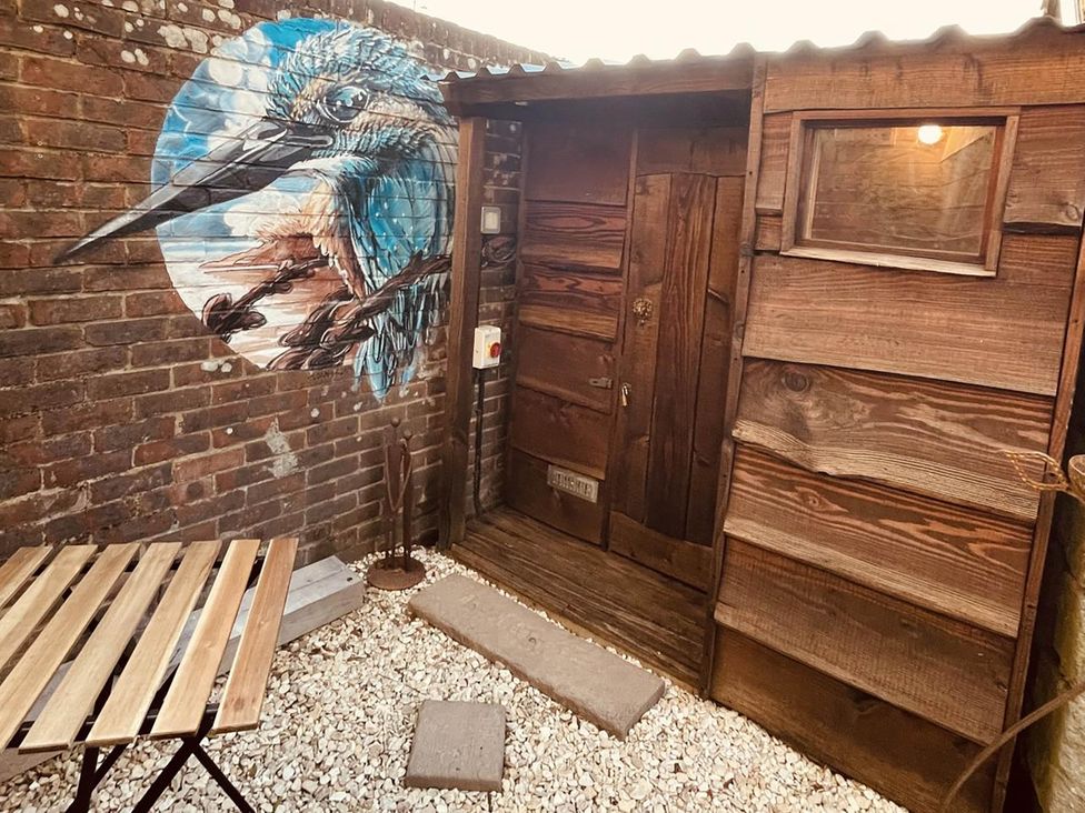 A garden area with a wooden door and mural at Charming Cottage Sleeps 4 with Sauna in Shaftesbury