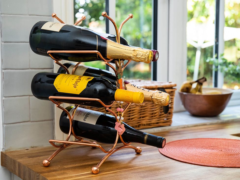 A wine rack holding bottles in a kitchen at 5Bed 10Guests Fireplace HotTub Pets ok Parking in Battle