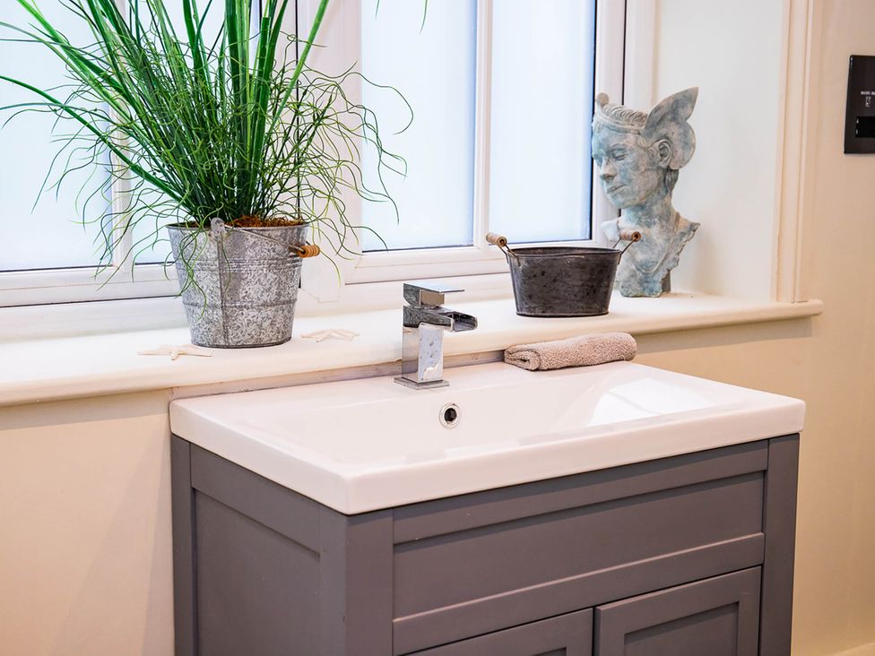 A bathroom sink with a plant and a sculpture at 5Bed 10Guests Fireplace HotTub Pets ok Parking in Battle