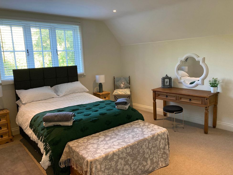 A bedroom with a bed and a dressing table at 5Bed 10Guests Fireplace HotTub Pets ok Parking in Battle
