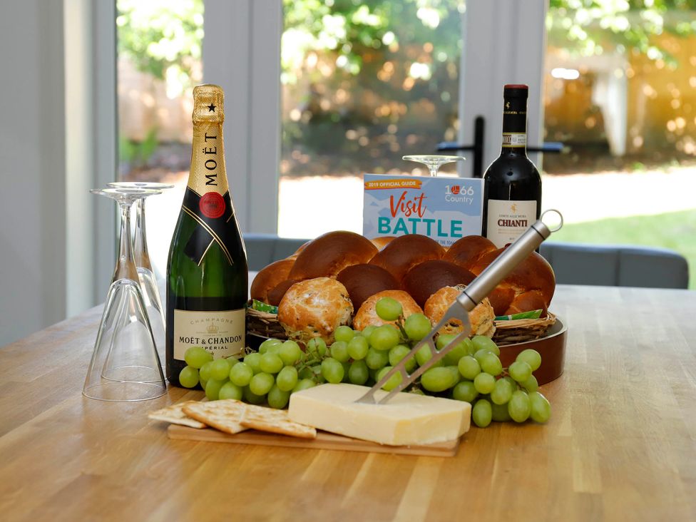 A table with champagne, wine, bread, cheese, grapes, and a brochure at 5Bed 10Guests Fireplace HotTub Pets ok Parking in Battle