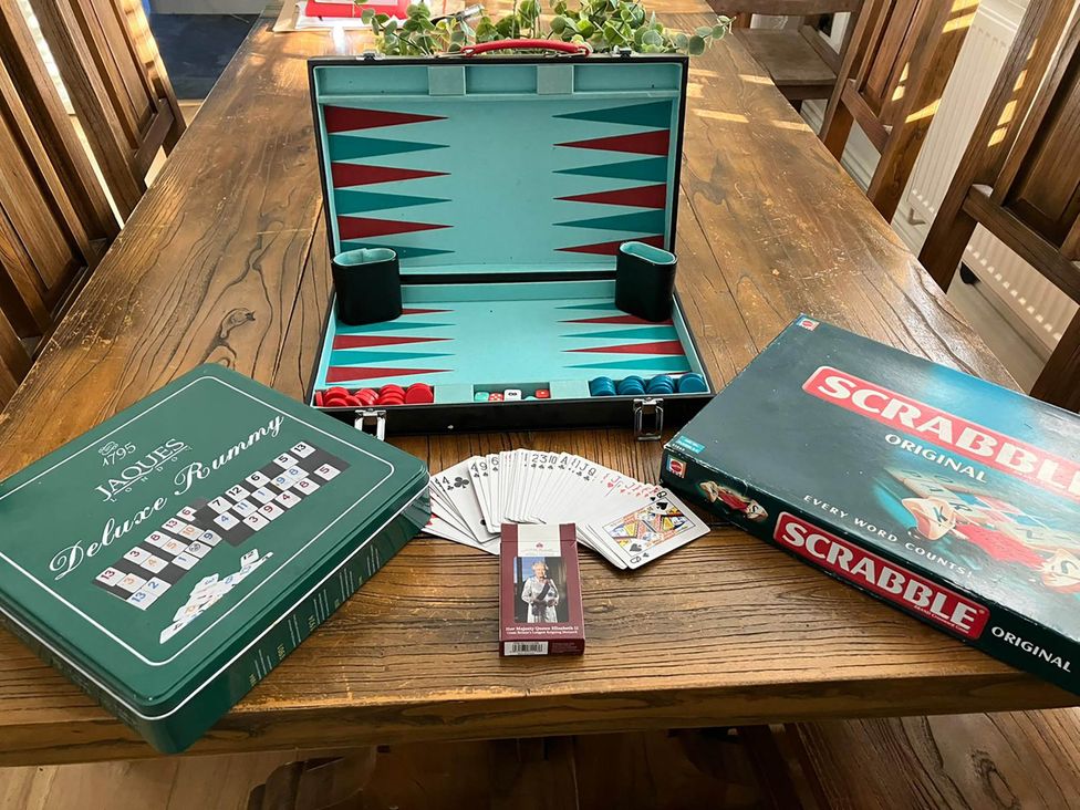 A collection of board games including Scrabble and Deluxe Rummy on a table at 5Bed 10Guests Fireplace HotTub Pets ok Parking in Battle