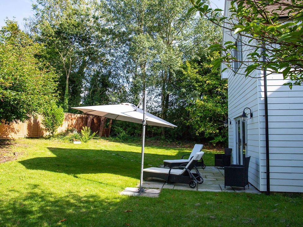 A garden with an umbrella and lounge chair at 5Bed 10Guests Fireplace HotTub Pets ok Parking in Battle