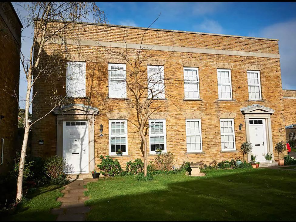 An outdoor view of a brick building with doors and windows at 3 bedroom house 3mins to beach PetsOk Milford On Sea