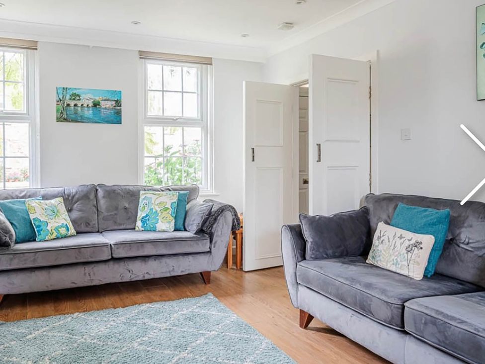 A living room with two sofas and a painting at 3 bedroom house 3mins to beach PetsOk in Milford On Sea