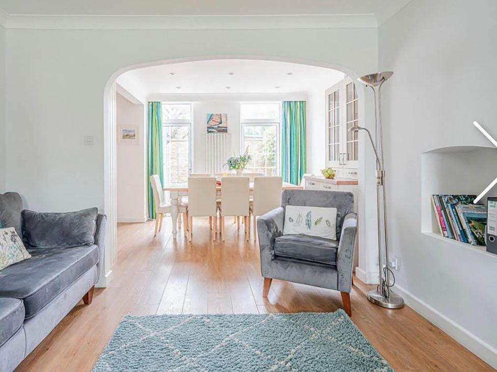 A living room with a sofa and a dining area at 3 bedroom house 3mins to beach PetsOk in Milford On Sea