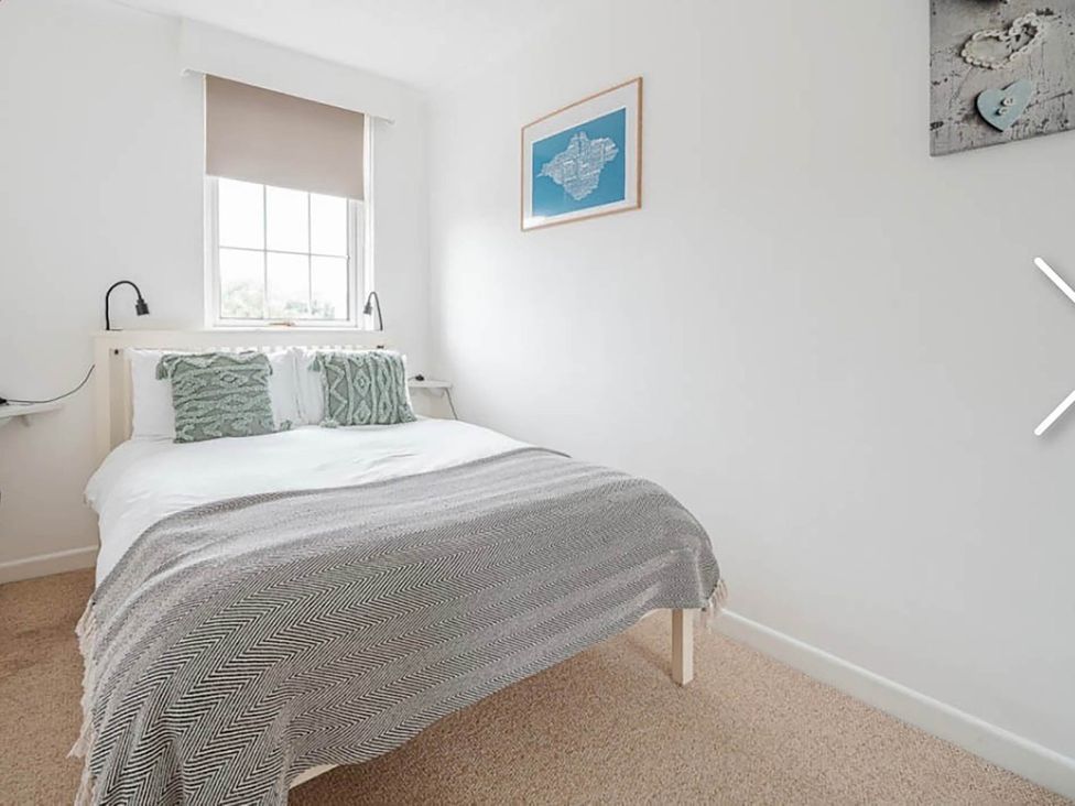 A bedroom with a bed and window at 3 bedroom house 3mins to beach PetsOk in Milford On Sea