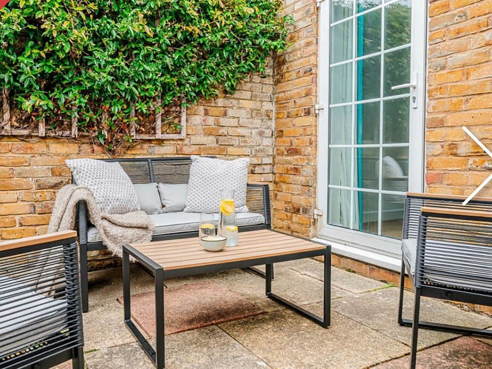 An outdoor seating area with a sofa and table at 3 bedroom house 3mins to beach PetsOk in Milford On Sea