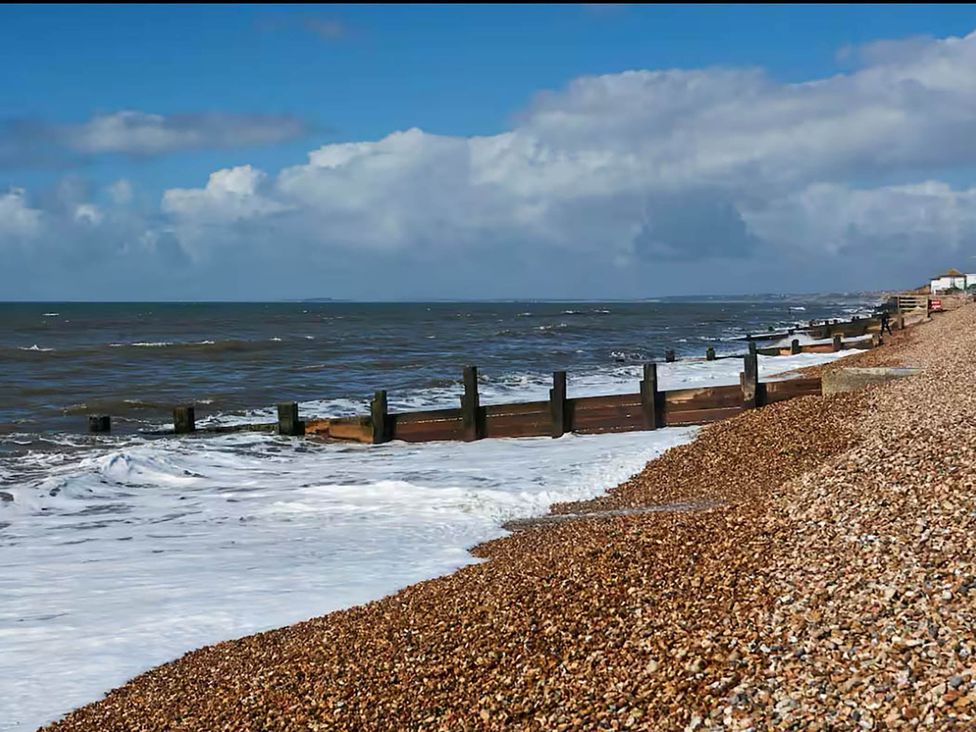 A beach with pebbles and wooden groynes at 3 bedroom house 3mins to beach PetsOk Milford On Sea