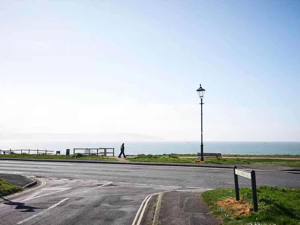 A person walking along a path by the ocean at 3 bedroom house 3mins to beach PetsOk in Milford On Sea