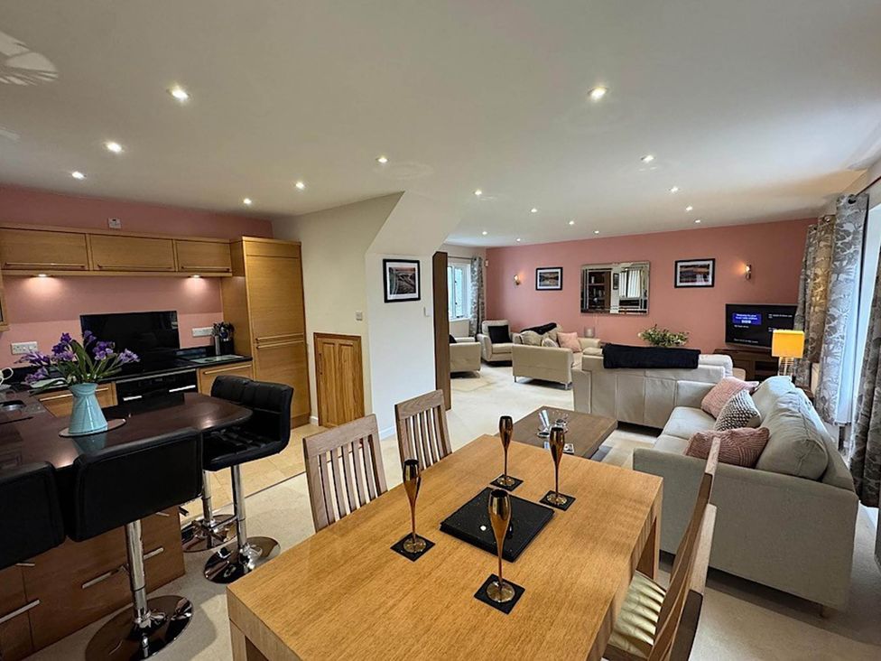 A dining area and living room with furniture at River Tamar Couples Retreat Dog Friendly in Newbridge