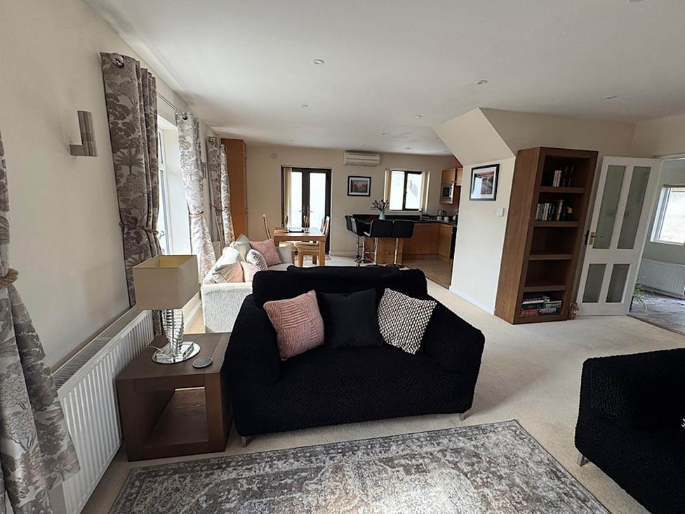 A living room with a sofa and a dining table at River Tamar Couples Retreat Dog Friendly in Newbridge