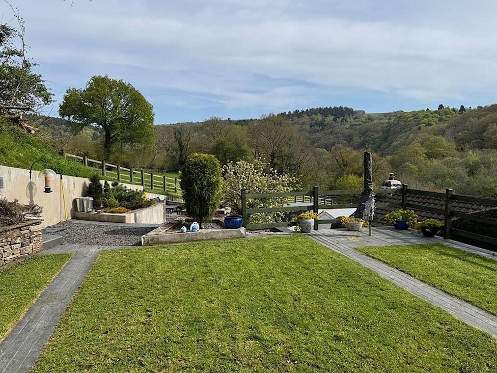 A garden with a fence and flower beds at River Tamar Couples Retreat Dog Friendly Newbridge