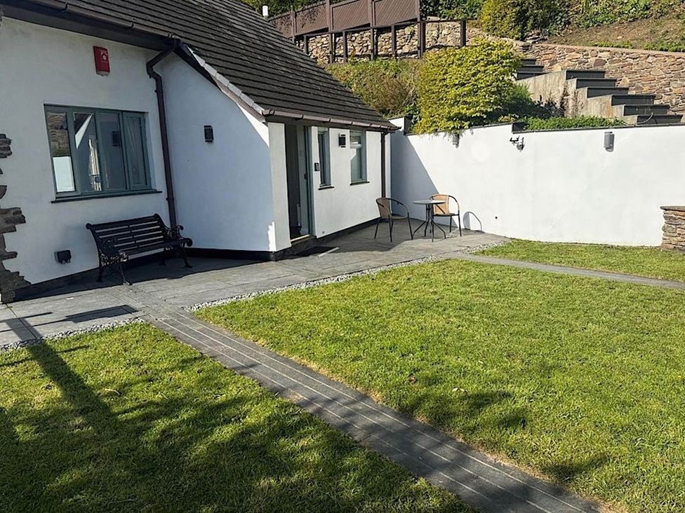 A garden with a bench and chairs at River Tamar Couples Retreat Dog Friendly Newbridge