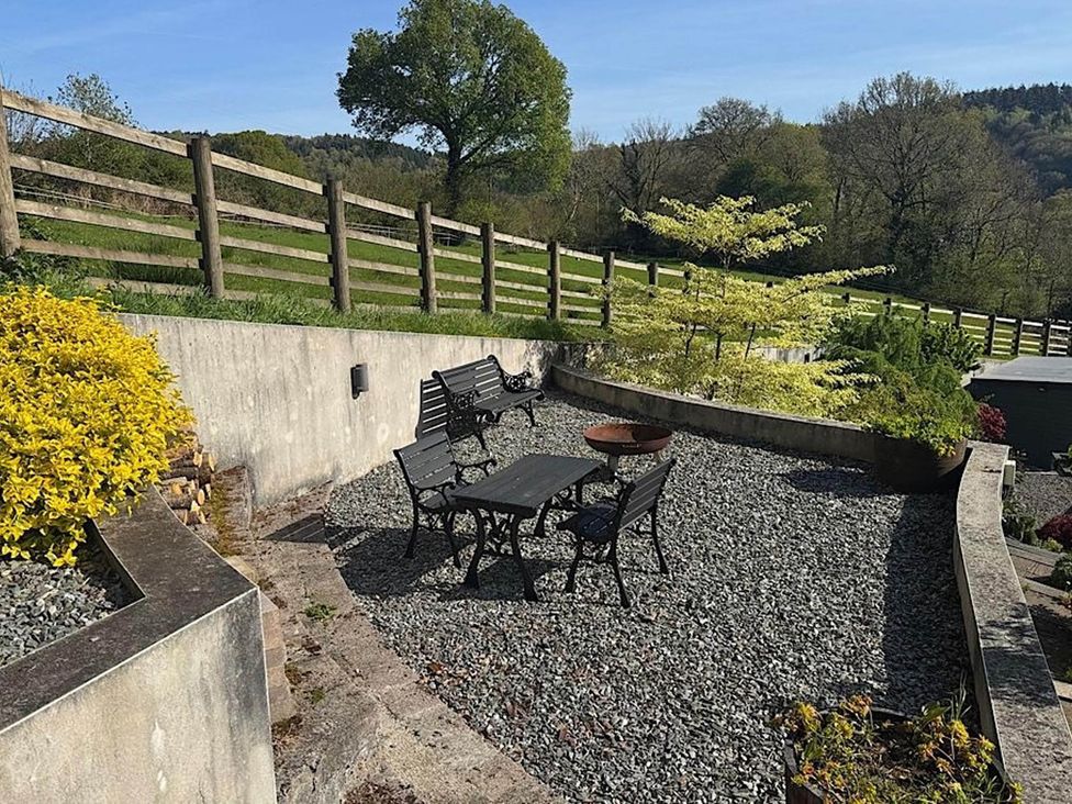 An outdoor seating area with a table and chairs at River Tamar Couples Retreat Dog Friendly in Newbridge