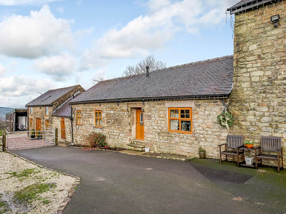 An outdoor view of a stone building with chairs and a pathway at The Stables at Brambles Farm Sleeps 2 Wifi, Leek