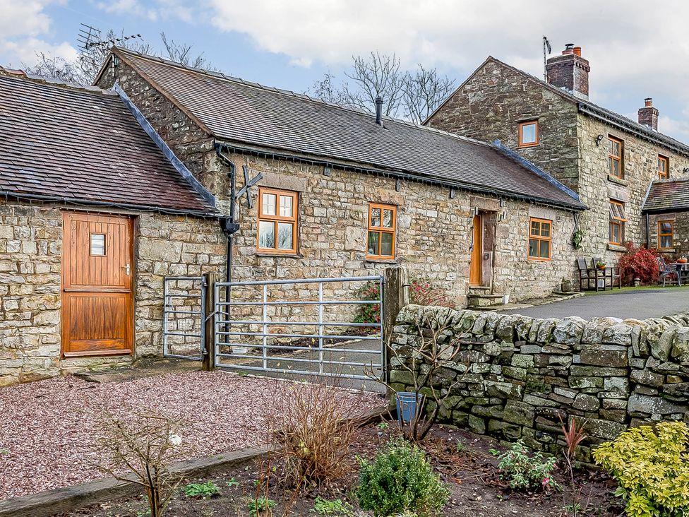 An outdoor view of a stone building with a gate and garden at The Stables at Brambles Farm Sleeps 2 Wifi, Leek