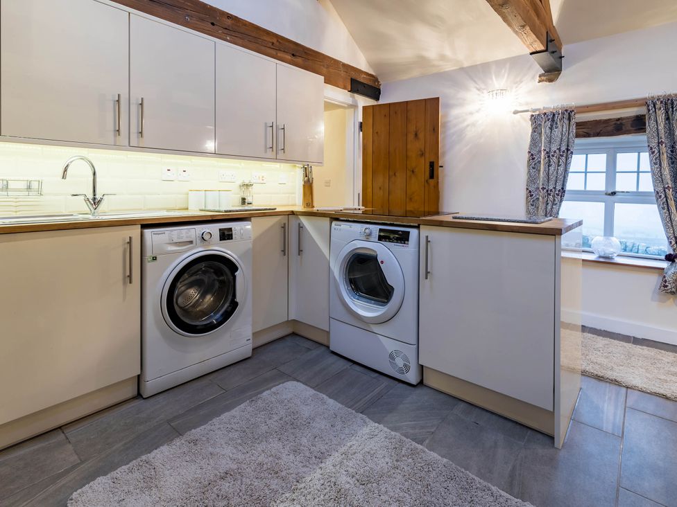 A laundry room with washing machine and tumble dryer at The Stables at Brambles Farm Sleeps 2 Wifi in Leek