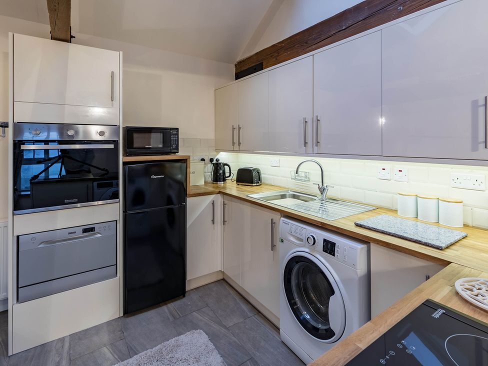 A kitchen with appliances and wooden countertop at The Stables at Brambles Farm Sleeps 2 Wifi in Leek