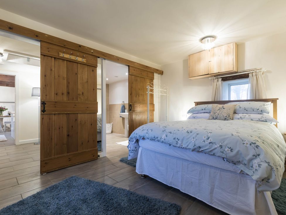A bedroom with a bed and sliding doors at The Stables at Brambles Farm Sleeps 2 Wifi in Leek