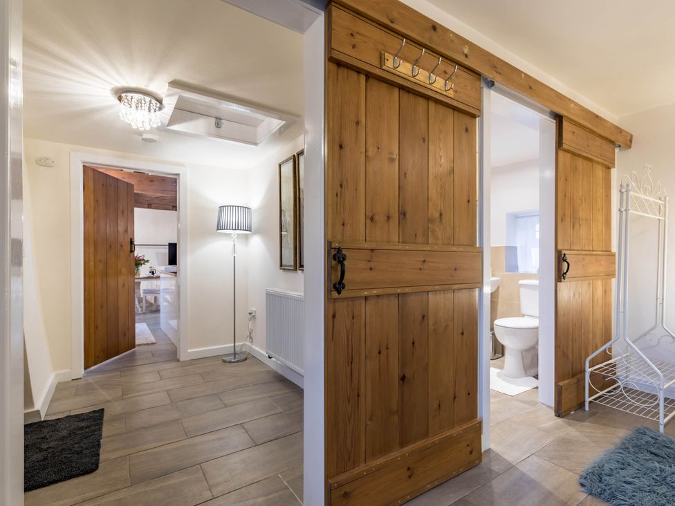 A hallway with wooden doors and a toilet at The Stables at Brambles Farm Sleeps 2 Wifi Leek