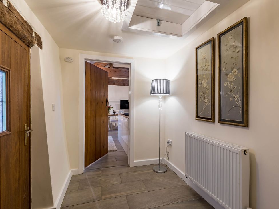 A hallway with a lamp and wall art at The Stables at Brambles Farm Sleeps 2 Wifi in Leek