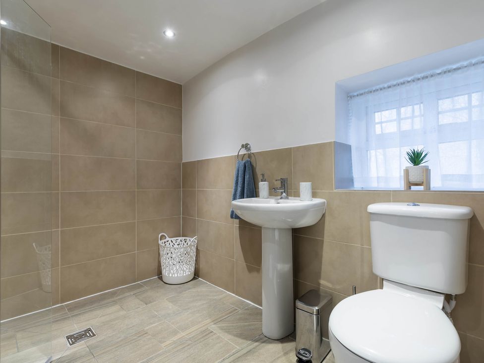 A bathroom with a shower, sink, and toilet at The Stables at Brambles Farm Sleeps 2 Wifi, Leek