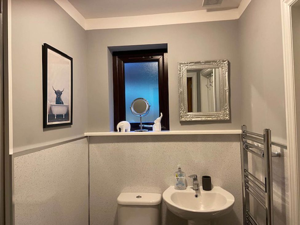 A bathroom featuring a sink, toilet, mirror and a window at Blairgowrie Luxury 3 Bed Lodge with Hot Tub in Blairgowrie