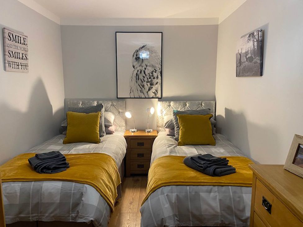 A bedroom with two beds and a bedside table at Blairgowrie Luxury 3 Bed Lodge with Hot Tub in Blairgowrie
