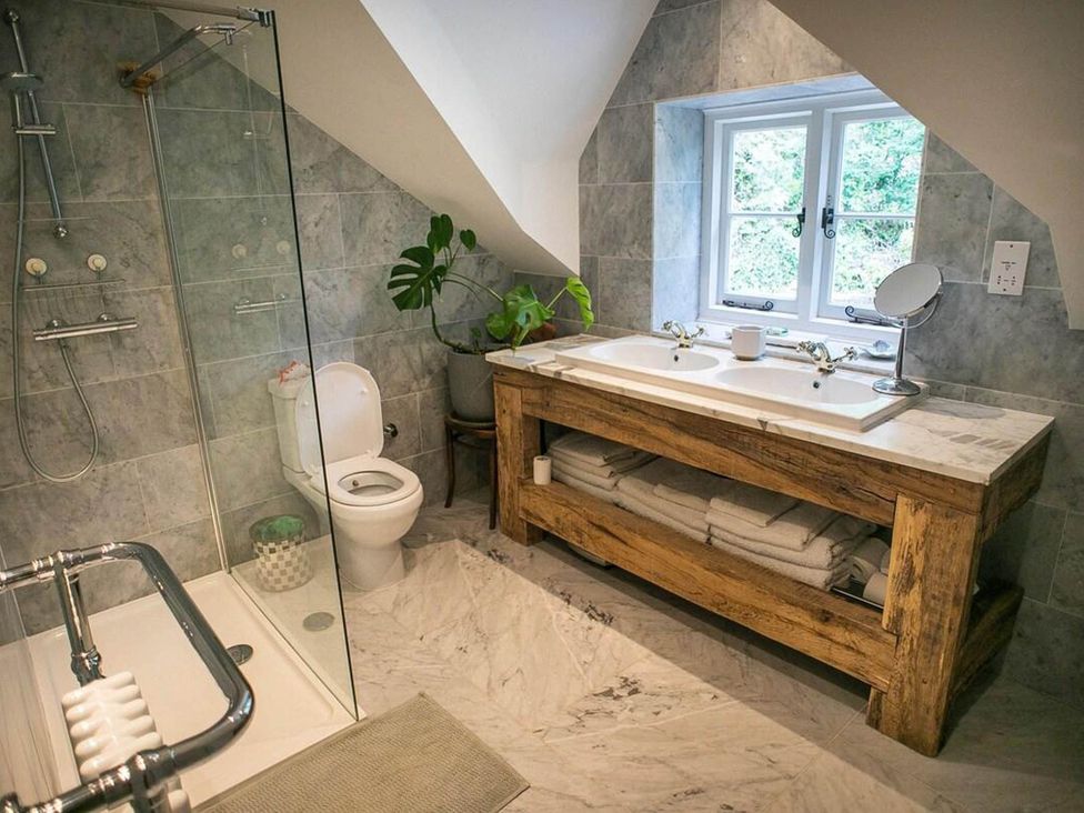 A bathroom with a shower, toilet, and dual sink at Cotswolds AoNB Cottage Modern Renovation Sleeps8 near Combe Hay Lane near Bath