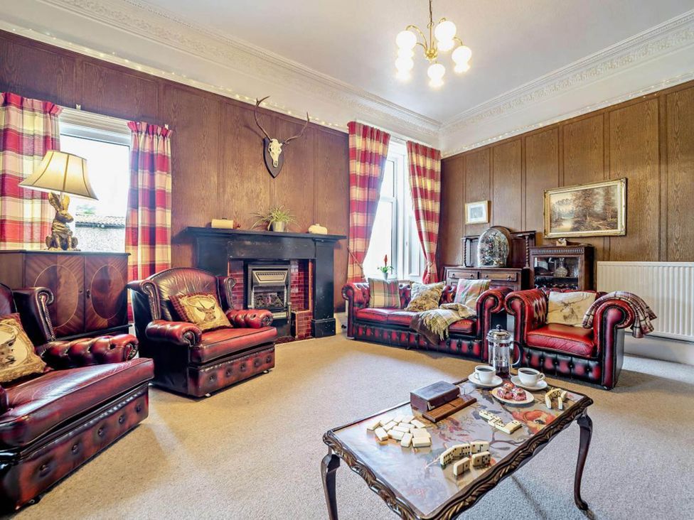 A living room with leather sofas and a fireplace at Dunoon Sleeps 17 Group Retreat with Parking in Kirn near Dunoon