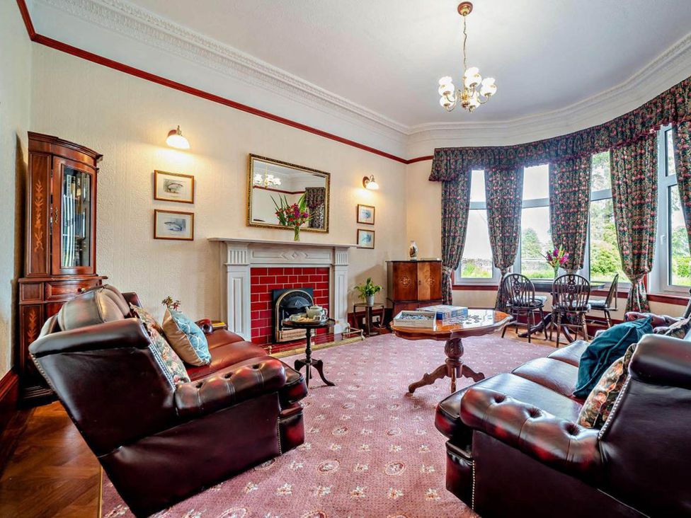A living room with a fireplace and sofa at Dunoon Sleeps 17 Group Retreat with Parking in Kirn near Dunoon