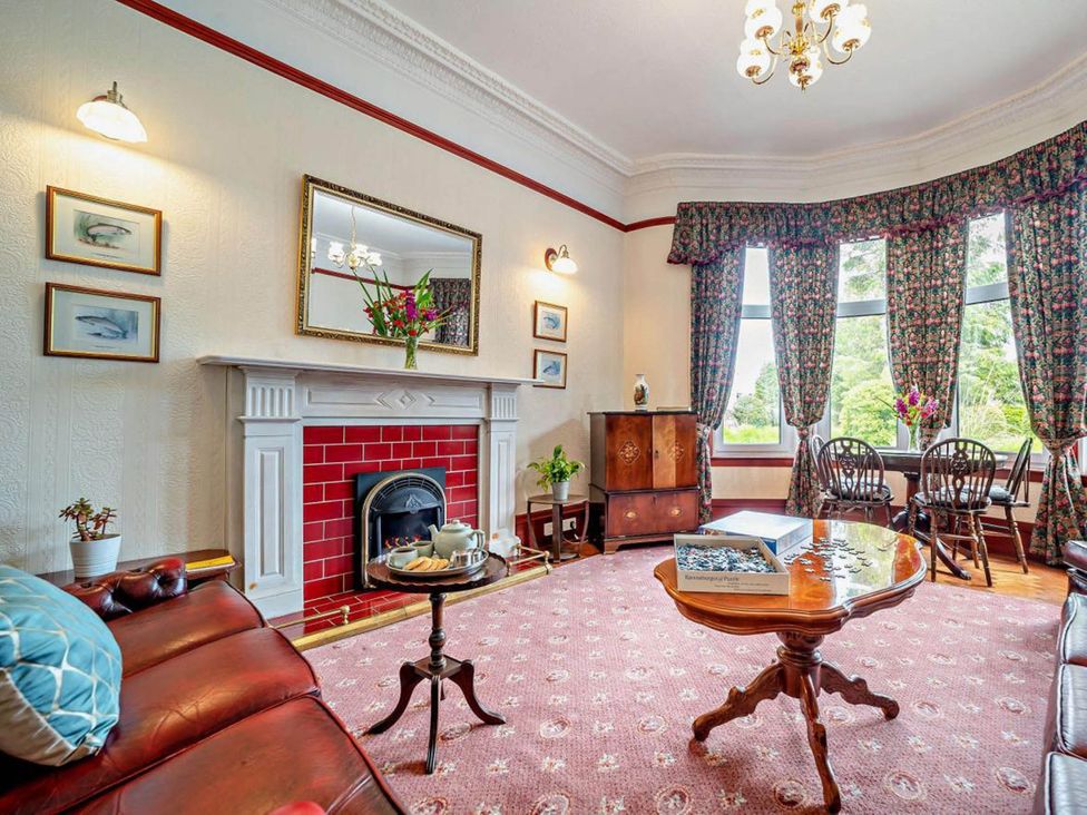 A living room with a fireplace and sofa at Dunoon Sleeps 17 Group Retreat with Parking Kirn near Dunoon