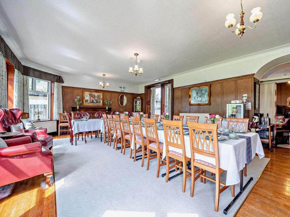 A dining room with a long table and chairs at Dunoon Sleeps 17 Group Retreat with Parking in Kirn near Dunoon