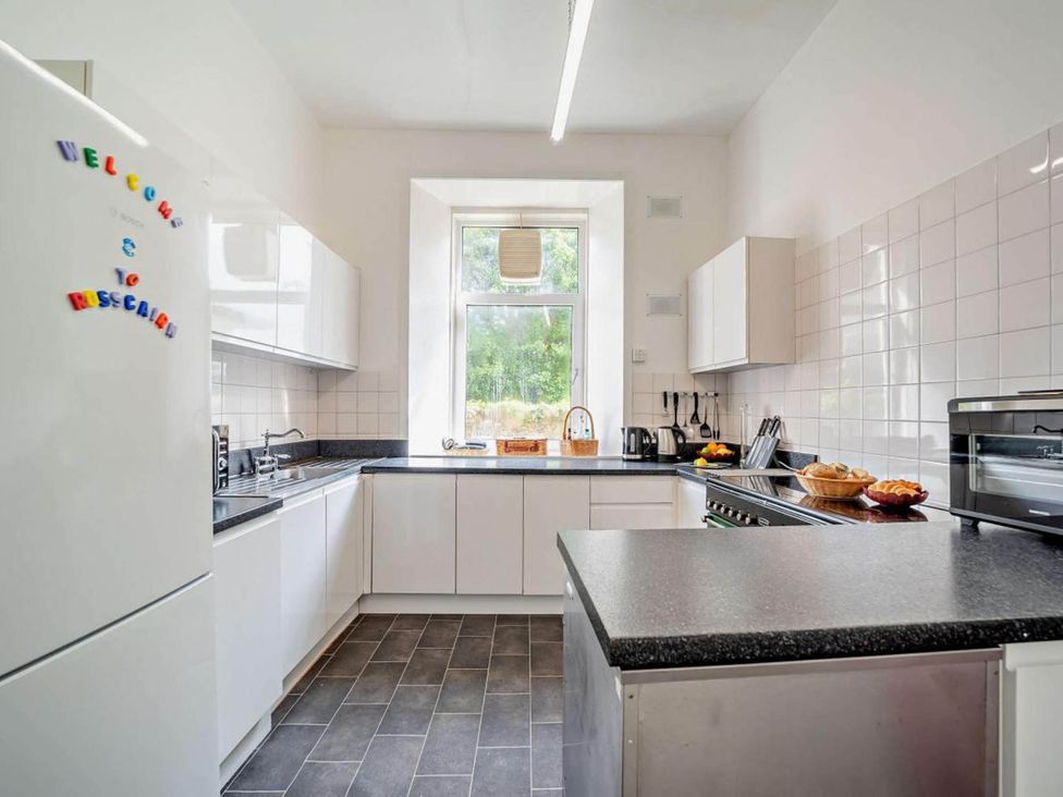A kitchen with modern appliances and a window at Dunoon Sleeps 17 Group Retreat with Parking Kirn near Dunoon