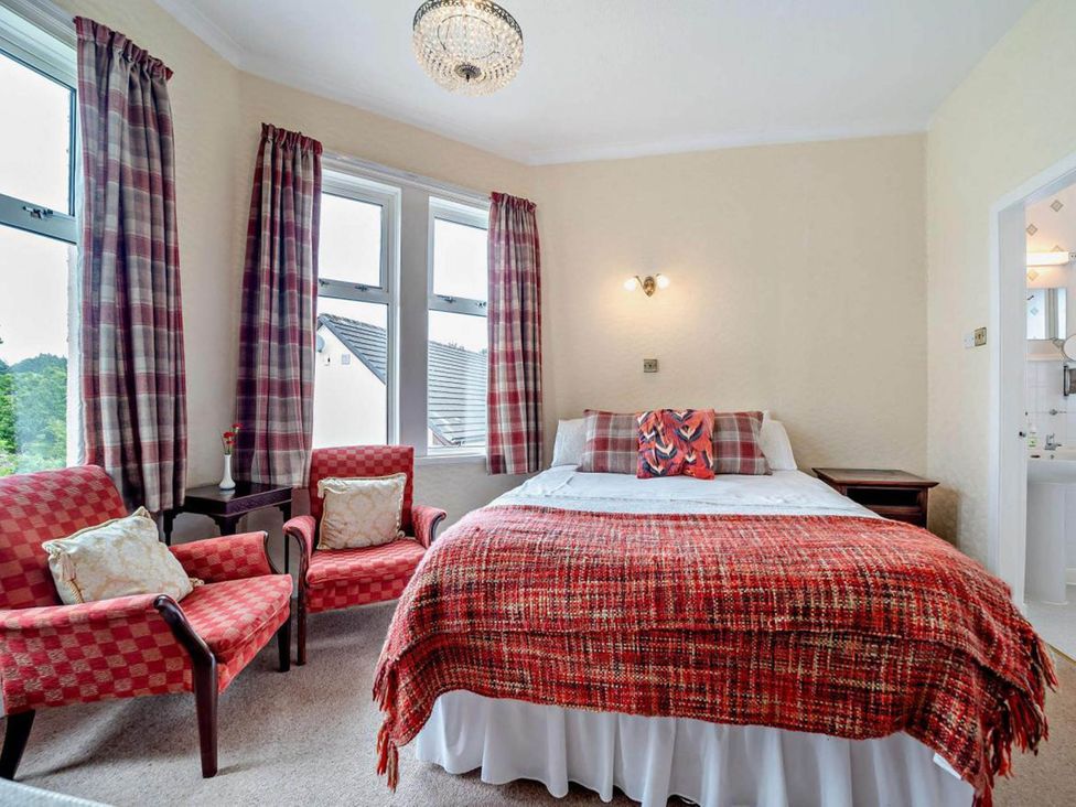 A bedroom with a bed and seating area at Dunoon Sleeps 17 Group Retreat with Parking in Kirn near Dunoon