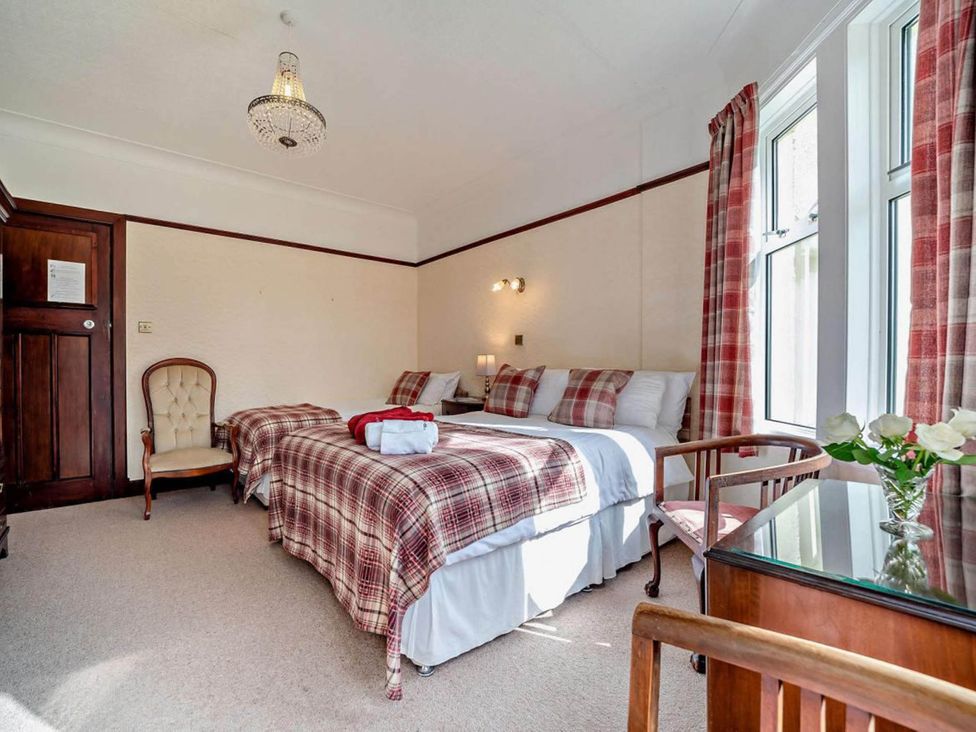 A bedroom with two beds and a chair at Dunoon Sleeps 17 Group Retreat with Parking Kirn near Dunoon