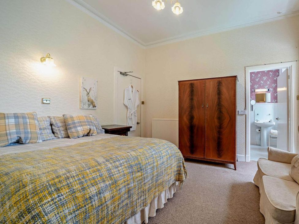 A bedroom with a bed and wardrobe at Dunoon Sleeps 17 Group Retreat with Parking Kirn near Dunoon